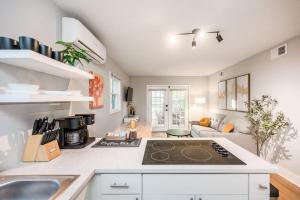 una cucina con fornello forno superiore accanto a un soggiorno di 3mi to Downtown Hot Tub Fire Pit a Garner