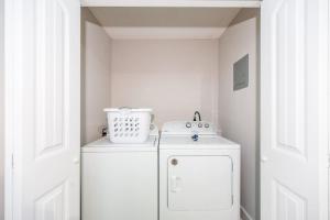 una piccola cucina bianca con un frigorifero bianco in una stanza di 3mi to Downtown Hot Tub Fire Pit a Garner