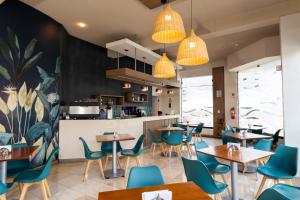 Un restaurante con mesas y sillas y una cocina. en VIP Hotel, en Ilo
