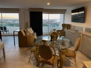 a kitchen and living room with a glass table and chairs at Hotel HBlue Malecón in La Paz