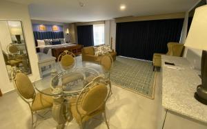 a living room with a glass table and chairs at Hotel HBlue Malecón in La Paz