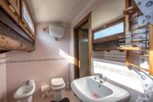 un bagno con lavandino, WC e finestra di Casa Ravacciano a Siena Altre 19 foto