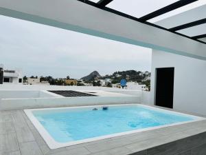 a large swimming pool in a white room with at Depa en el Centro Historico By GPSRentas in Isla Cardones