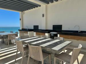 Un comedor con mesa y sillas y el océano. en Lujoso Depa con Vista al Mar by Partner Host, en Mazatlán