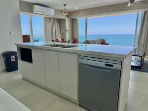 cocina con fregadero y ventana grande en Lujoso Depa con Vista al Mar by Partner Host, en Mazatlán
