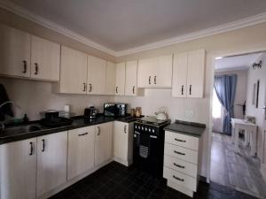 米德兰Sunflower Stables Cottage in the Garden的厨房配有白色橱柜和黑炉。