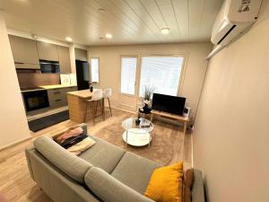 a living room with a couch and a kitchen at Convenient Apartment for 2 in Kotka