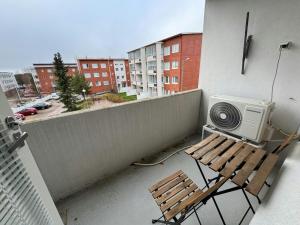 a balcony with a wooden bench and a fan at Convenient Apartment for 2 in Kotka