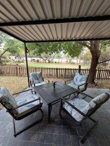 米德兰Sunflower Stables Cottage in the Garden的露台遮阳伞下的一张桌子和两把椅子