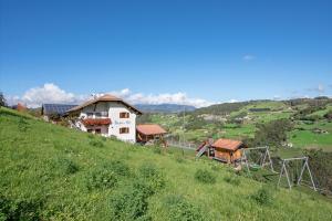 a house on top of a hill with a playground at Wohnung Schlern Heigler Hof in Collepietra +17 photos