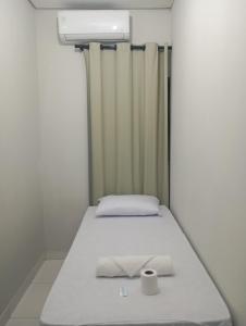 a small bedroom with a bed with a roll of toilet paper on it at hotel pousada Maanaim in Palmas +9 photos