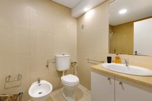 une salle de bains avec toilettes et lavabo dans l'établissement Apartamento T1 - Tróia Resort, à Tróia 13 autres photos