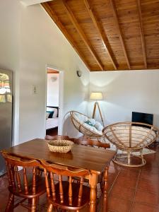 a living room with a wooden table and chairs at Casa Ponta do Biscoito in Caminho de Cima