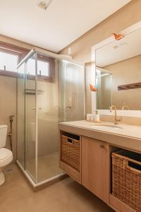 a bathroom with a shower and a sink and a toilet at Bali Bahia 202 Frente ao mar Itacimirim in Itacimirim