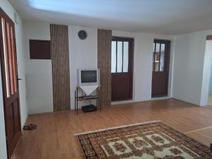 an empty living room with a television and a rug at Topole 2 
