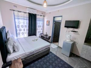 una camera da letto con un letto e una TV a schermo piatto di Stay simple lodge a Lusaka