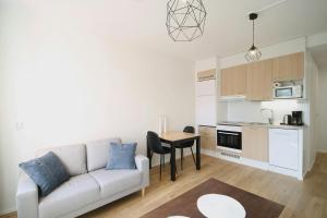 een woonkamer met een witte bank en een tafel bij Convenient Apartment for 2 in Kouvola