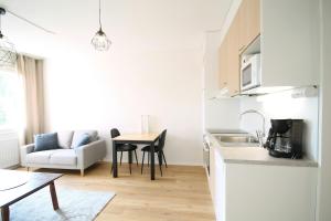 een keuken en woonkamer met een tafel en een bank bij Convenient Apartment for 2 in Kouvola +1 foto