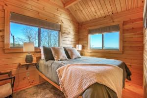 a bedroom with a bed in a log cabin at Hillside Hideaway - Hot Tub in Brookville