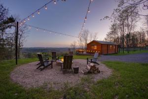 a group of chairs and a fire pit in front of a cabin at Sanctuary Summit - Hot Tub in Brookville