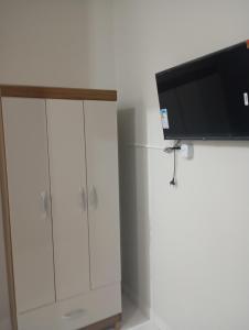 a white cabinet with a flat screen tv on top at hotel pousada Maanaim in Palmas