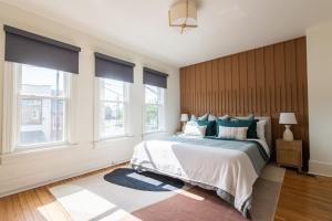 a bedroom with a large bed and two windows at The Lancastrian House Downtown in Lancaster