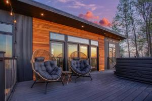 two wicker chairs sitting on the deck of a house at Skyline Serenity - Hot Tub in Brookville +5 photos