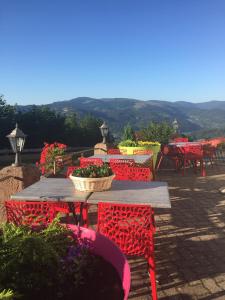 a table with red chairs and flowers on a patio at Hôtel Panorama in Munster