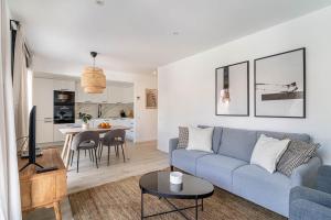 サン・クガ・デル・バリェスにあるThe Sweet House - BBQ y piscinaの青いソファとキッチンのあるリビングルーム