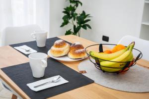 a table with a bowl of fruit and a bowl of donuts at San Nicola House in Enna