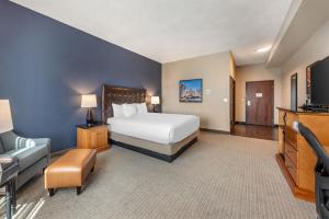a large hotel room with a bed and a tv at Drury Plaza Hotel San Antonio North Stone Oak in San Antonio