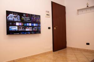 a room with a flat screen tv on a wall at San Nicola House in Enna