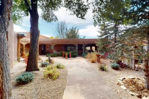 een binnenplaats van een huis met bomen en een patio bij Historic Hacienda in Ranchos de Taos