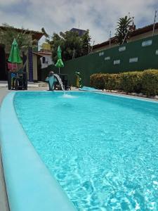 a person is playing in the water in a swimming pool at Pousada e Hostel F C in Natal