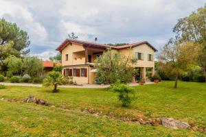 une maison avec une pelouse verte devant dans l'établissement Casa Le Basse - Giuncarico, à Gavorrano