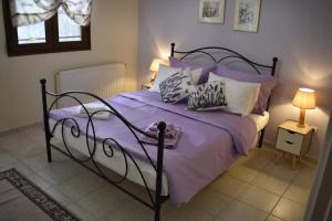 Un dormitorio con una cama con sábanas y almohadas púrpuras. en STRAVOS-PLATANOS apartement, en Nausa