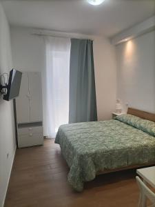 a bedroom with a bed and a television in it at D&D home in Mola di Bari