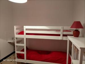 a bedroom with two bunk beds and a lamp at Le Landrin in Pénestin +7 photos