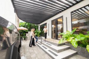 two people standing on the porch of a house at La Residence Panamá in Panama City