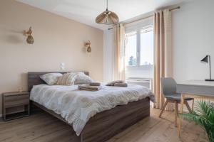 a bedroom with a bed with a desk and a desk at Le Cocon des Allamandières in Chonas-lʼAmballan