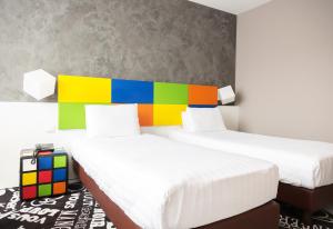 ラ・ルヴィエールにあるHotel Tristarのカラフルなヘッドボード付きのベッド2台が備わる客室です。