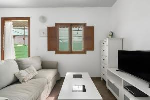 ein Wohnzimmer mit Couch und Flachbildfernseher in der Unterkunft Country Studio Near Fataga in Artedara