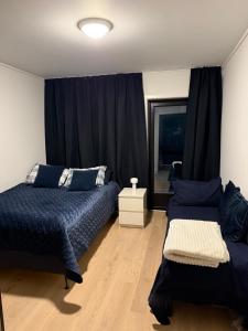 a bedroom with two beds and a window at Nordheim Aparment in Tromsø