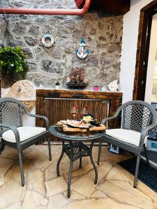 a patio with two chairs and a table with wine glasses at Casa Ipogeo in SantʼAntìoco