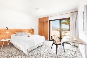 サンタ・エウラリア・デス・リウにあるアパルタメントス バイーアのベッドとテーブルと椅子のあるホテルの部屋