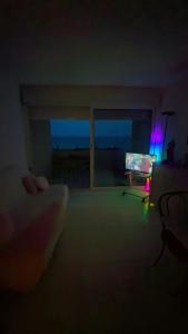 a person holding a remote in a dark room with a laptop at Appartement première ligne vue mer in Aresquies