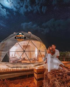een bruid en bruidegom staan voor een yurt bij ROYAL SAVOY lUXURY CAMP in Wadi Rum