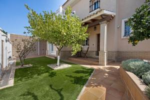 ein Haus mit einem Baum im Hof in der Unterkunft Chalet con Piscina Privada in Poblado de Sancti Petri