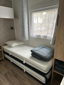 sypialnia z dwoma łóżkami i oknem w obiekcie MH295 3chambres et 1 salle de bain de 40m2 dans camping 4 étoiles w mieście Saint-Julien-en-Born