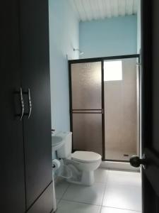 a bathroom with a toilet and a glass shower door at Narv extrema in Utica
